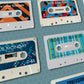 Cassette style poster featuring New Order's Factory single releases
